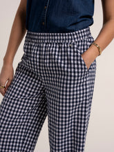 Load image into Gallery viewer, Person wearing navy and white checkered pants with a plain background
